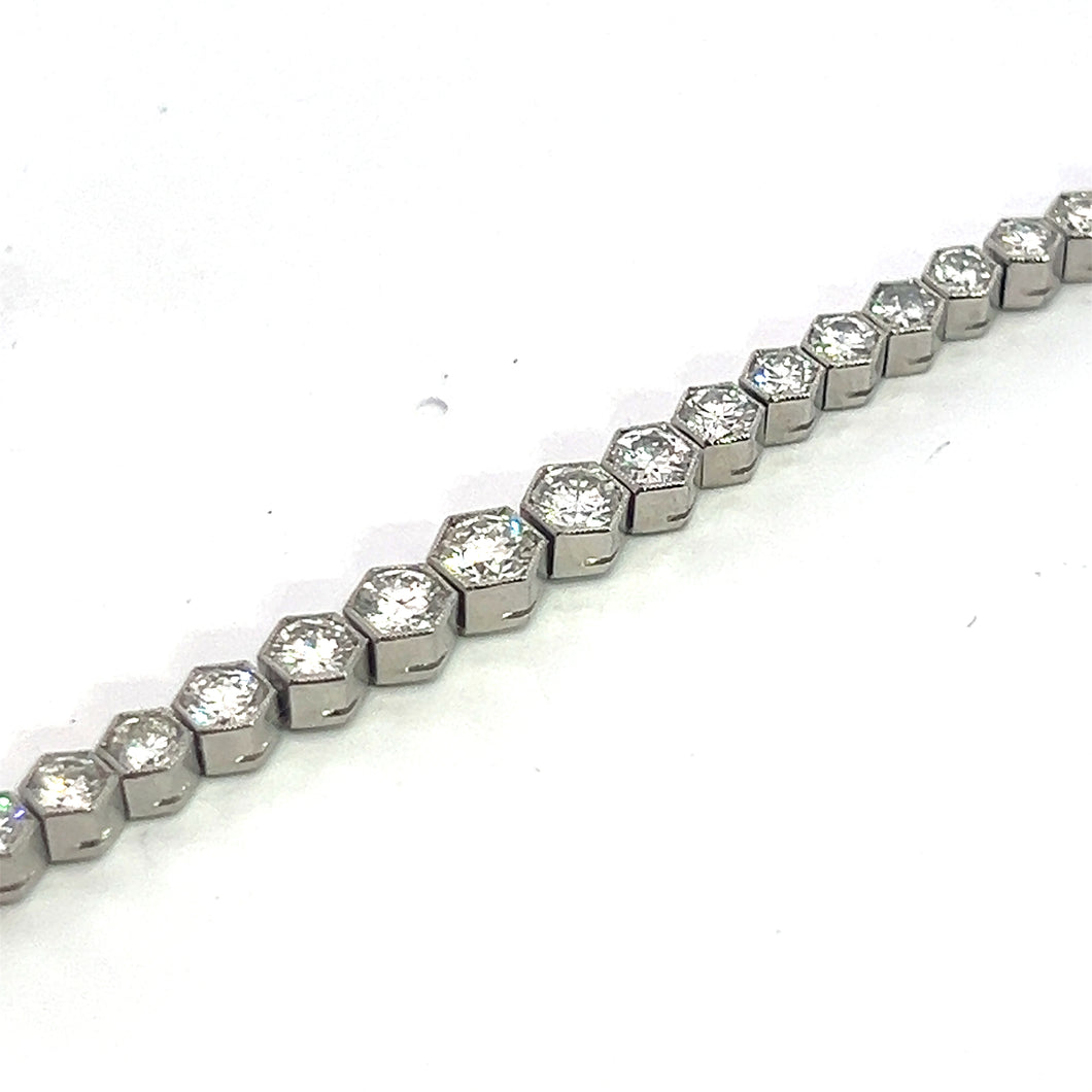 A close-up view of the Art Deco Platinum 4.90cttw Diamond Bezel Set 7.25inch Bracelet, featuring a series of hexagonal segments, each carefully bezel set with a small diamond. The bracelet is laid out in a straight line on a white background, showcasing its uniform and sparkly design reminiscent of classic Art Deco jewelry.