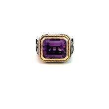 Load image into Gallery viewer, A Konstantino Late Century ring featuring an emerald-cut, 5-carat amethyst set in the center. The amethyst is framed by 18kt yellow gold accents, and the sterling silver band is adorned with intricate black detailing. This ring is displayed upright against a white background.