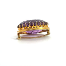 Load image into Gallery viewer, The Victorian 14kt Yellow Gold 24ct Oval Amethyst Brooch showcases a large, oval-shaped amethyst stone set in an elegant yellow gold frame with intricate prongs. Exuding the sophistication of the Victorian era, it features a secure pin clasp on the back. The faceted amethyst reflects light with a mesmerizing purple hue against a plain white background.