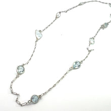 Load image into Gallery viewer, The &quot;Mid Century Platinum approx 5ct multi shape aquamarine by the yard 20 inch necklace&quot; is a delicate piece featuring variously shaped aquamarines. These crystals, with their subtle blue tint, reflect the craftsmanship of the Mid Century era. The necklace includes teardrop, oval, and round aquamarine shapes that are evenly spaced along its 20-inch chain.