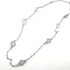 The "Mid Century Platinum approx 5ct multi shape aquamarine by the yard 20 inch necklace" is a delicate piece featuring variously shaped aquamarines. These crystals, with their subtle blue tint, reflect the craftsmanship of the Mid Century era. The necklace includes teardrop, oval, and round aquamarine shapes that are evenly spaced along its 20-inch chain.