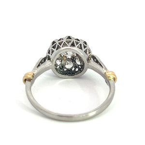 Displayed is a stunning Edwardian Platinum & 18kt Yellow Gold 1.30cttw Old Mine Cut Diamond Ring. It features a round central diamond surrounded by Old Mine cut diamonds, with gold accents on the band near the setting. Positioned upwards, it highlights the detailed craftsmanship and intricate design.