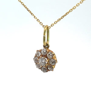 A Victorian 14kt yellow gold necklace with a 1.16 cttw Old Mine Cut Diamond Pendant in the shape of a flower, featuring several small, clear gemstones arranged in a circular pattern, hangs against a white background. The chain is delicate and lightweight.