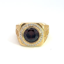 Load image into Gallery viewer, The Late Century 14ktyg 4.5ct garnet + .75cttw diamond ring features a prominent, dark garnet gemstone at its center, accentuated by a circle of smaller clear diamonds. The ring showcases an exquisite late-century design on the band, enhancing its ornate aesthetic. Displayed against a plain white background, this garnet and diamond ring makes a striking impression.