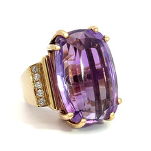 Load image into Gallery viewer, The Late Century 14kt yellow gold ring showcases a stunning 33-carat faceted oval amethyst as its centerpiece, accented by small decorative diamonds totaling .70 carats on one side of the band. The vibrant purple amethyst is highlighted by multiple facets and securely set with gold prongs.