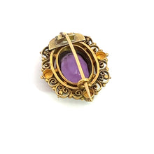 Load image into Gallery viewer, The Victorian 14ktyg 4.70ct Amethyst + seed pearl pin showcases an elegant and decorative vintage design with an ornate gold-toned setting, intricate scrollwork, and a central purple amethyst gemstone. Reminiscent of Victorian-era jewelry, this exquisite piece features a pin and clasp mechanism for fastening, making it a refined accessory to enhance any ensemble.