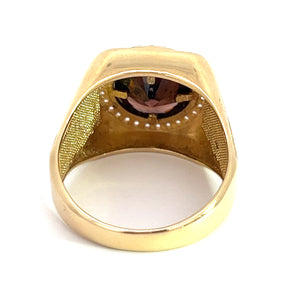 A Late Century 14ktyg ring with a broad band and an inset gemstone, viewed from the side of the band showing the inside. The interior is finely textured, creating a contrast with the smooth outer surface. The 14kt yellow gold ring features a 4.5ct garnet and .75cttw of diamonds positioned at the top but not fully visible from this angle.