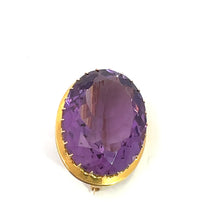 Load image into Gallery viewer, The Victorian 14kt Yellow Gold 24ct Oval Amethyst Brooch exudes elegance with its deep purple, oval-shaped gemstone secured by small prongs. This simple yet stunning brooch allows the vibrant amethyst to stand out beautifully against a plain white background.