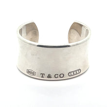 Load image into Gallery viewer, A wide-cuff ring in silver with a split at the back, prominently displaying the engravings &quot;925,&quot; &quot;T &amp; CO,&quot; and the 1837 hallmark on the front. The ring has a smooth, polished surface that exudes contemporary style, reminiscent of the Modern Tiffany Sterling Silver Cuff Bracelet c.2001.