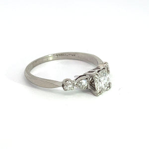 A vintage Art Deco piece, this ring features a central .50ct Old European cut diamond flanked by two smaller Old Mine cut diamonds totaling .28cttw, set in a minimalist band design. Crafted from polished platinum, the ring is showcased against a plain white background, accentuating its timeless elegance.