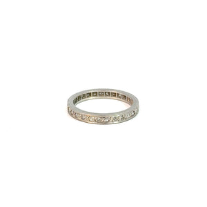 A thin silver ring featuring a band of small, sparkling diamonds set around its circumference, displayed against a plain white background. This Art Deco Platinum .50cttw Diamond Eternity Band has a simple and elegant design, symbolizing eternal love with its timeless beauty and charm.