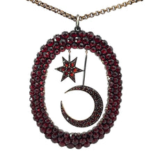 Load image into Gallery viewer, The Victorian Vermeil Star &amp; Moon Large Pendant, encrusted with dark red gemstones and surrounded by an oval border adorned with the same red gems, hangs beautifully from a 21-inch 15kt yellow gold Victorian chain, capturing celestial motifs perfectly.