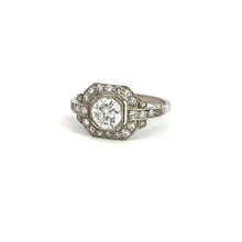 Load image into Gallery viewer, The Late Art Deco Platinum .91ct Round Brilliant Cut Diamond + 1.16cttw Diamond Ring exudes vintage sophistication and Art Deco elegance with its large round central diamond set in an intricate geometric design, surrounded by smaller diamonds, all beautifully showcased against its white background display.