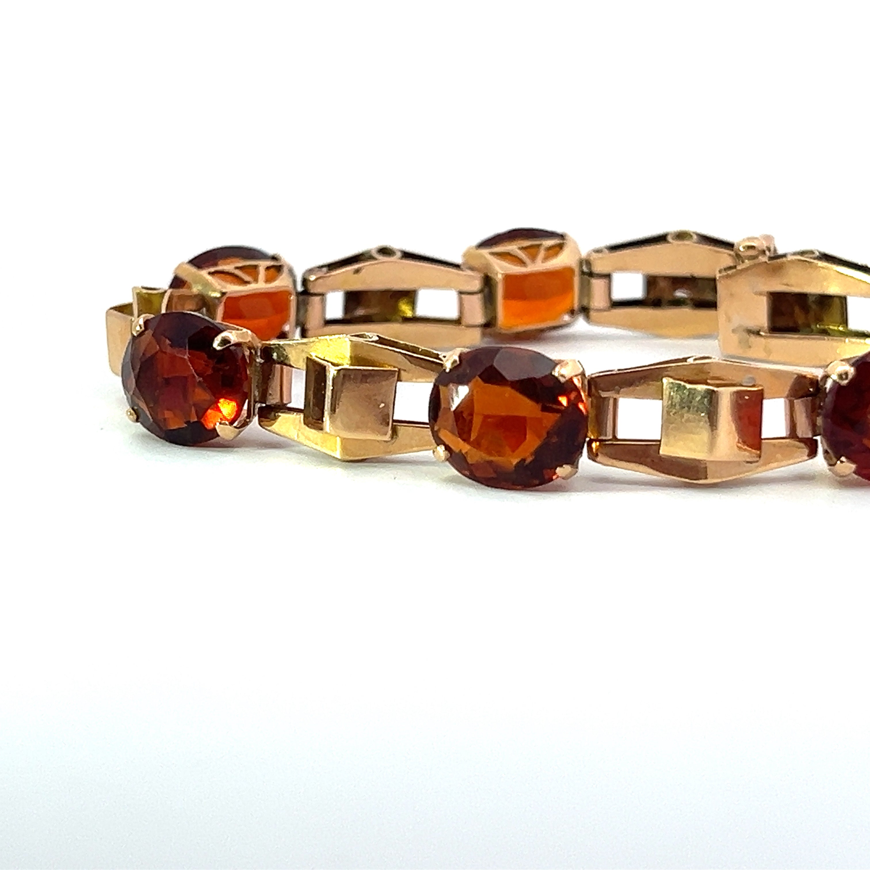 The Retro 14kt Yellow Gold 30cttw Madeira Citrine 7in Bracelet showcases a series of alternating links featuring rectangular gold pieces and oval, deep orange Madeira Citrine gemstones. The bracelet exudes retro charm with its geometric, elegant design, highlighting gemstones mounted in gold settings.