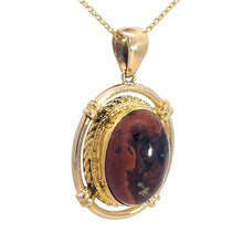 Load image into Gallery viewer, Introducing the Late Century 14kt Yellow Gold 5ct Boulder Opal Fancy Frame Pendant: a gold pendant necklace featuring a polished oval red and black boulder opal gemstone encased in a decorative gold setting. Reminiscent of vintage charm, this exquisite pendant hangs from a delicate gold chain and showcases intricate detailing around the stunning gemstone.