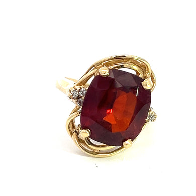 The Late Century 14kt Yellow Gold 7.50ct Oval Garnet Ring features a large, oval-shaped garnet at its center, surrounded by intricate gold detailing and small accent diamonds. The garnet boasts a deep, rich red hue, and the ring's elegant and ornate design is crafted from 14kt yellow gold.