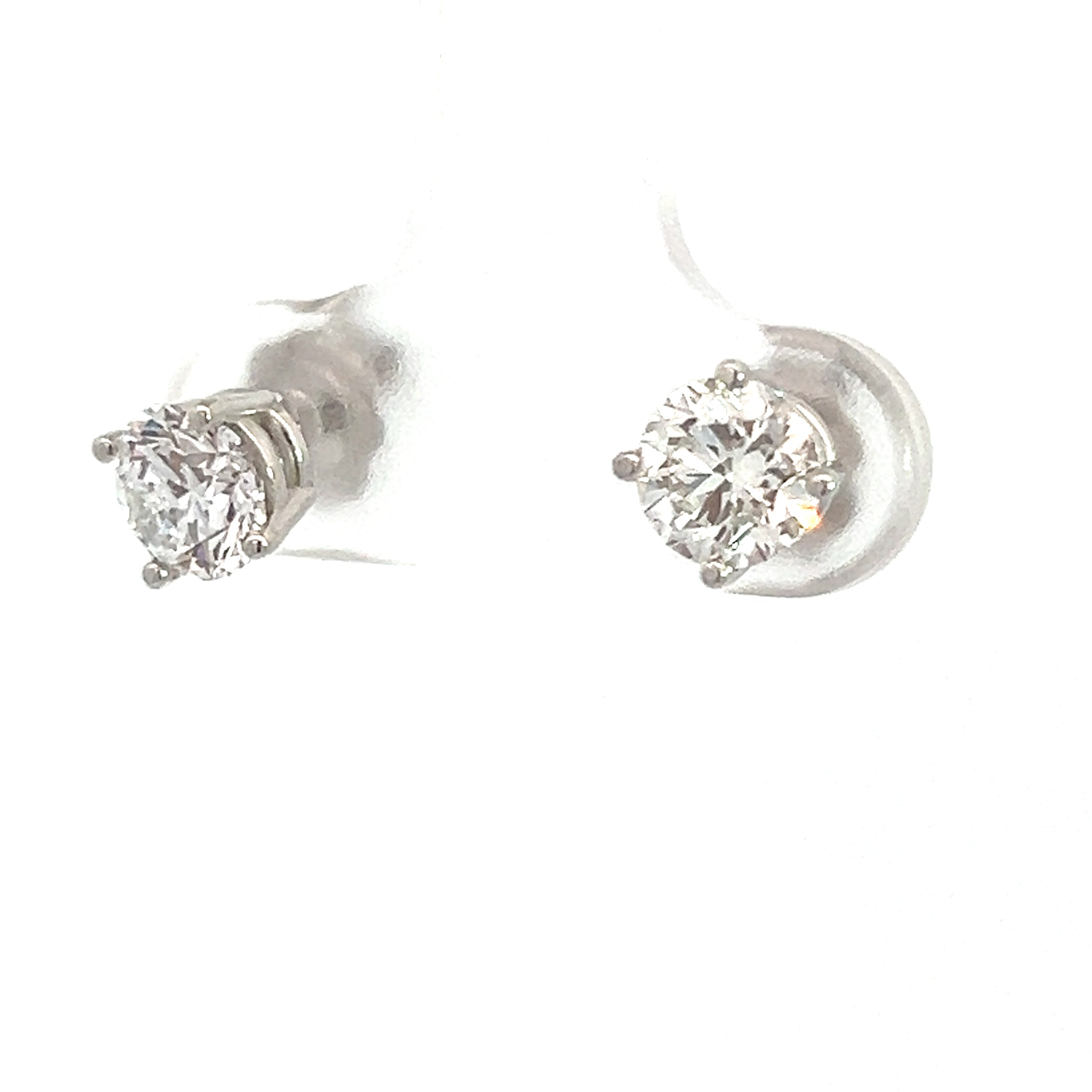 The Modern 14kt White Gold 1.41cttw Round Brilliant Cut Diamond Studs are elegantly showcased on a transparent holder against a white background. These exquisite diamond stud earrings feature round brilliant cut diamonds set in a classic four-prong setting, crafted in elegant 14kt white gold.
