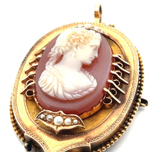 Load image into Gallery viewer, A close-up view of the Victorian 14ktyg Carved Agate Portrait of a Lady Cameo pendant reveals its ornate, oval-shaped design. The pendant showcases a white, intricately carved agate portrait of a woman&#39;s head against a reddish background. The frame is made of 14kt yellow gold and is adorned with pearl accents and decorative details, enhancing its vintage appeal.