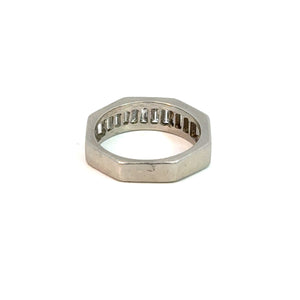 A silver octagonal ring with a smooth, polished surface and a detailed inner design is shown against a plain white background. The ring boasts classic elegance with its angular, modern appearance and defined edges, reminiscent of the Late Century Platinum Henri Carre 1.50cttw Emerald Cut Diamond Band.