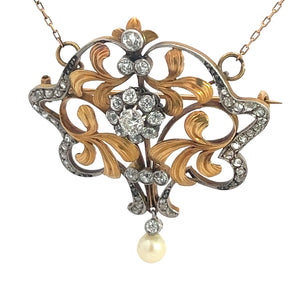 The Edwardian Platinum & 18kt Yellow Gold 4.35cttw Old Mine, Rose cut Diamond & Pearl Necklace exudes ornate, vintage elegance with its swirling gold and silver designs. It features several small diamonds arranged in floral patterns and a single pearl hanging from the bottom, all attached to a delicate chain.