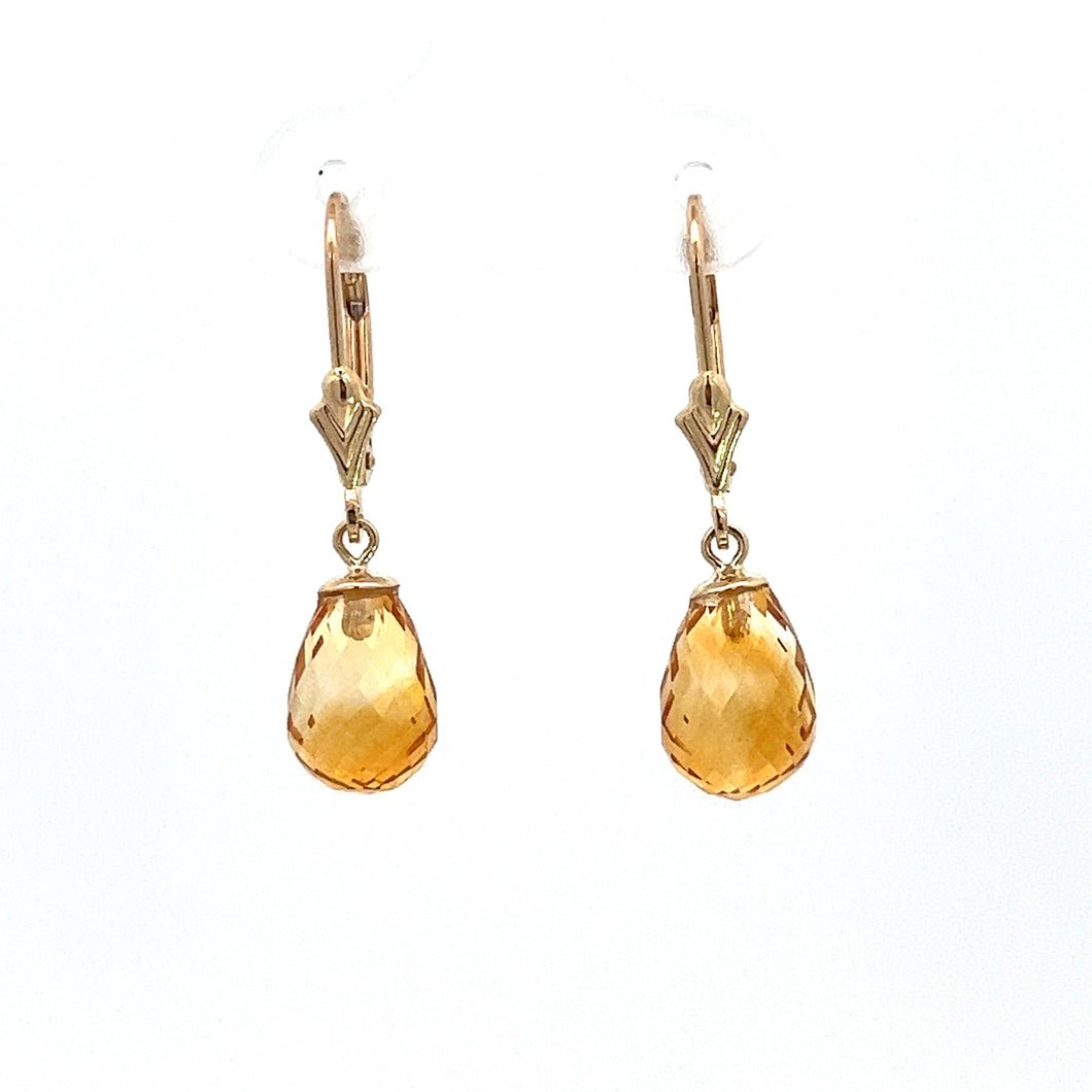 A pair of modern 14kt yellow gold briolette citrine earrings, each showcasing a teardrop-shaped, faceted citrine gemstone that hangs from a lever-back clasp, epitomizes the charm of contemporary dangle earrings.