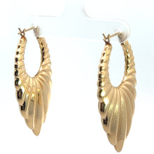 Load image into Gallery viewer, A pair of Late Century 14kt Yellow Gold Textured Drop Earrings, featuring a unique twisted and textured design that radiates vintage charm, displayed elegantly on a clear stand against a white background. The earrings are crafted from 14kt yellow gold and boast a shiny, polished finish.