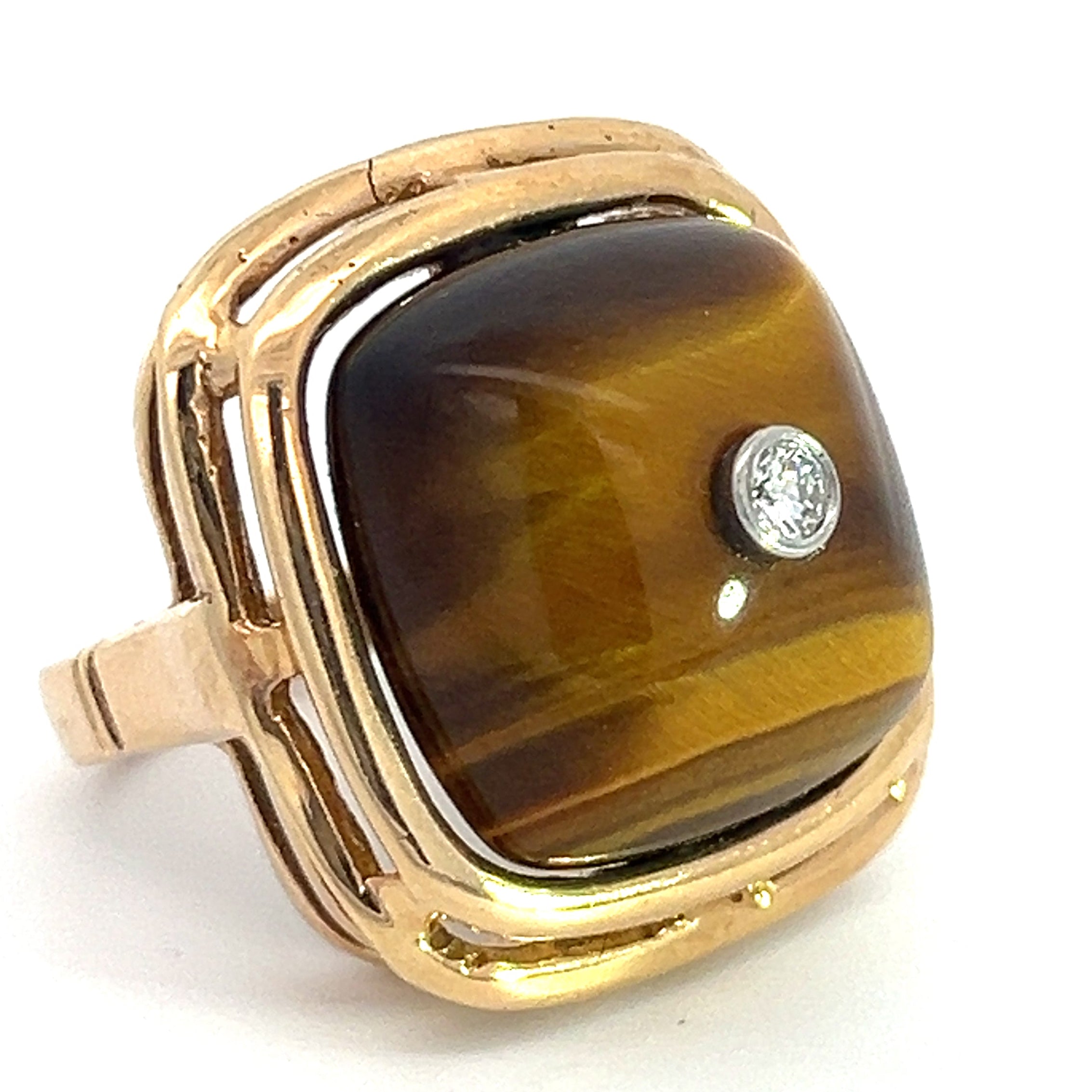 Introducing the Late Century 14ktyg Tiger Eye + .10ct Round Brilliant Cut Diamond ring: a square-shaped gold ring showcasing a polished tiger's eye gemstone, presenting its signature golden and brown bands. The center is adorned with a small, round brilliant cut diamond, all enveloped in a smoothly finished, shiny gold setting.