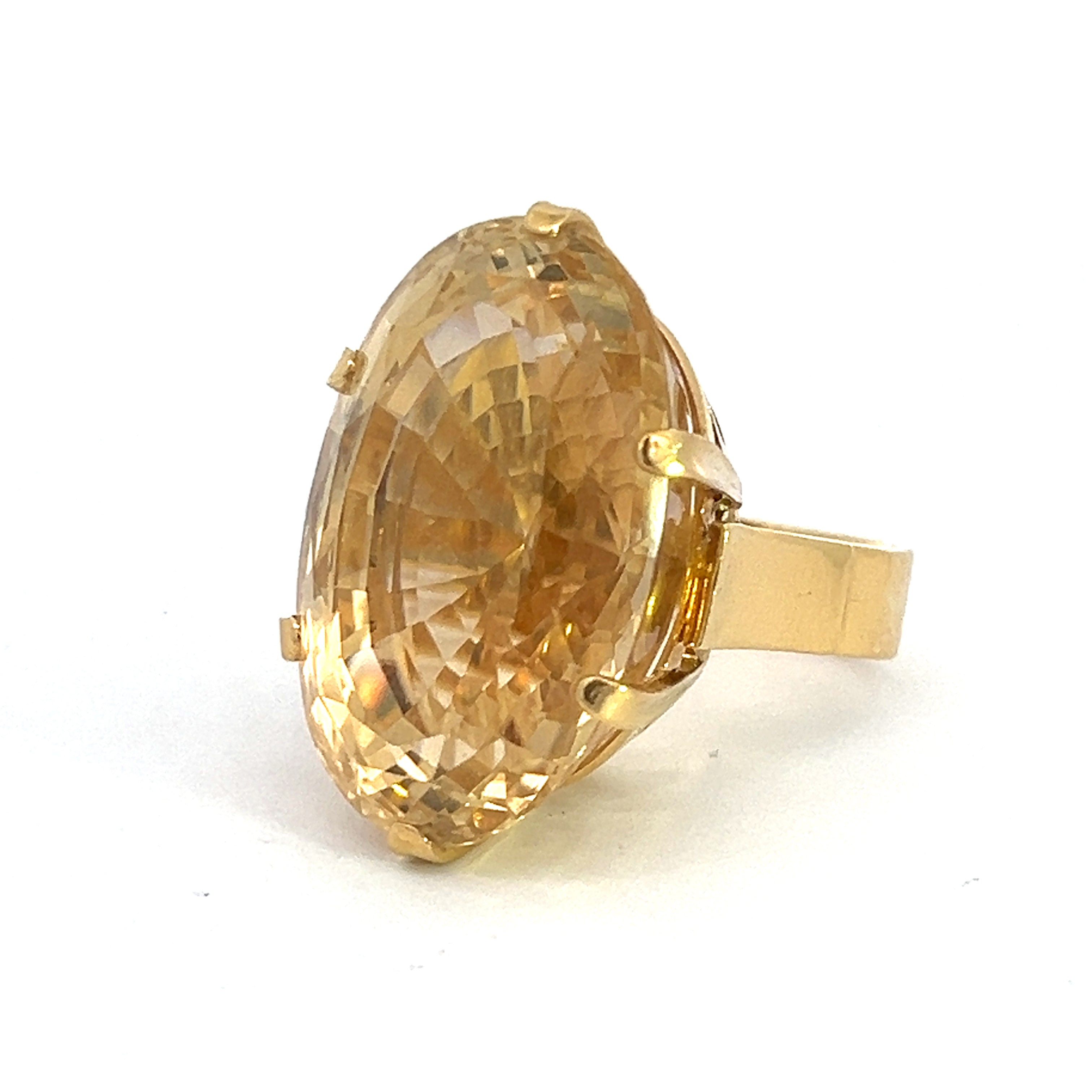 The Late Century 18ktyg 22ct Oval Citrine Ring features a gold oval-shaped band adorned with a large, faceted yellow citrine gemstone set in a six-prong setting. The intricate internal facets of the citrine catch and reflect light, creating a dazzling sparkling effect against the plain white background.