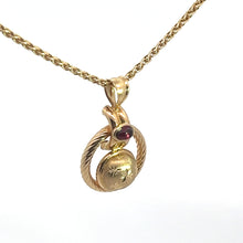 Load image into Gallery viewer, An elegant Victorian 14k yellow gold necklace featuring a .50 carat cabochon garnet pendant with a diamond-cut design. The intricately detailed pendant includes a small red gemstone and a ring-like motif, all suspended from an 18-inch twisted gold chain. The presentation is set against a plain white background.