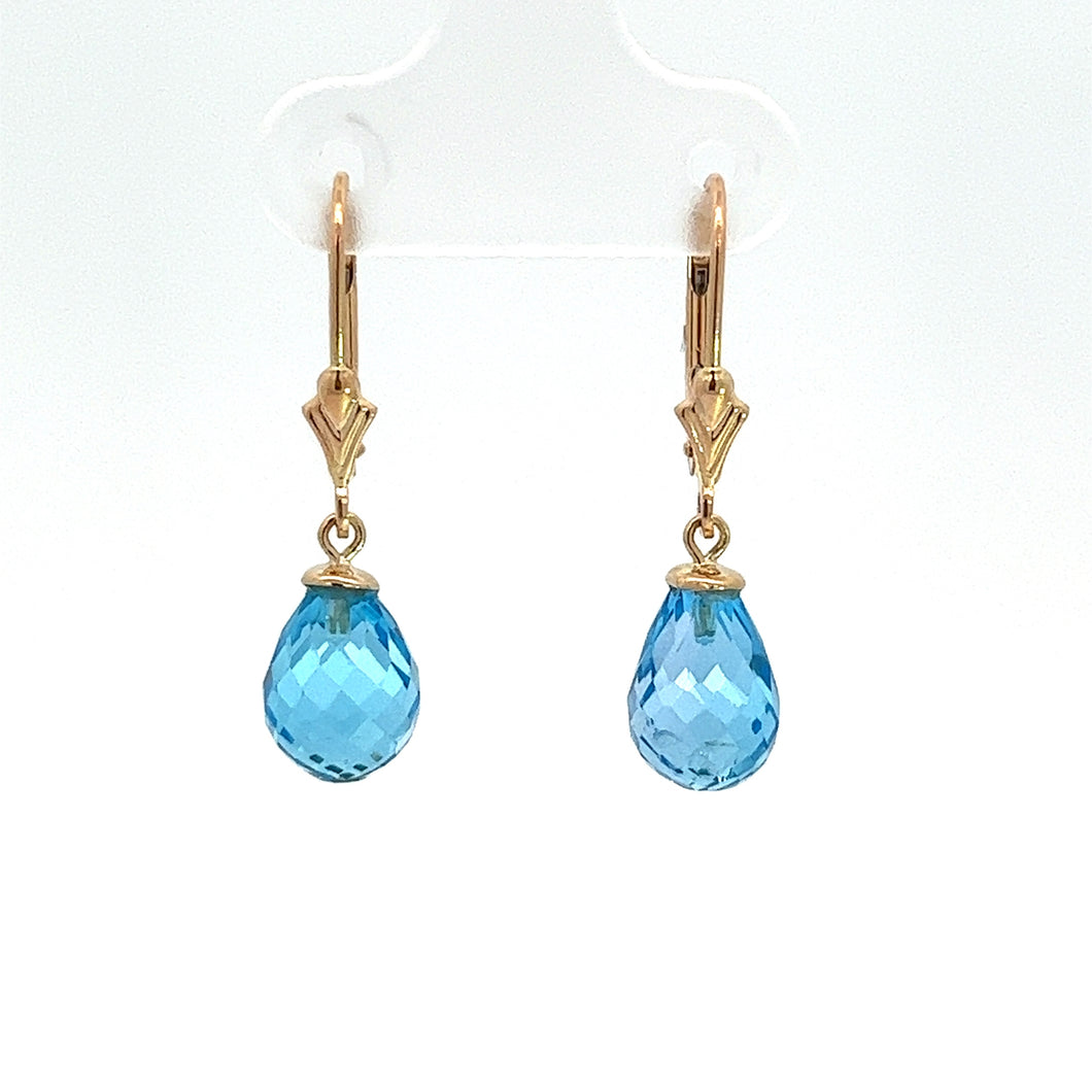 The Modern 14ktyg briolette blue topaz earrings are a pair of elegant drop earrings with teardrop-shaped blue topaz gemstones, set in 14k yellow gold. Intricate gold hooks and clasps add a touch of sophistication, while the briolette-cut facets on the gemstones create a brilliant sparkle, beautifully highlighted against a plain white background.