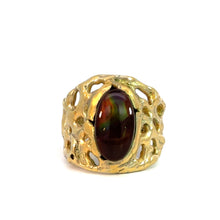 Load image into Gallery viewer, The Late Century 14ktyg Freeform 5ct Fire Agate Ring boasts a gold band with an intricate, perforated design. At its center lies a large, oval-shaped Fire Agate gemstone characterized by a dark hue and multicolored hints of red and green. This vintage-inspired piece exudes charm and is elegantly showcased against a plain white background.