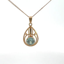 Load image into Gallery viewer, This Art Nouveau 14kt Yellow Gold 2ct Blue Zircon Necklace features a large, round blue zircon set in an open teardrop-shaped metal frame with intricate Art Nouveau design details, all complemented by a fine and delicate gold chain.