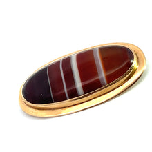Load image into Gallery viewer, The Victorian 10ktyg Banded Agate Pin is a treasure from the Victorian era, featuring an inlaid agate stone with striking horizontal bands of white, red, and dark brown colors set in yellow gold. This antique piece of jewelry, perfect against a white background, adds timeless elegance to any attire.
