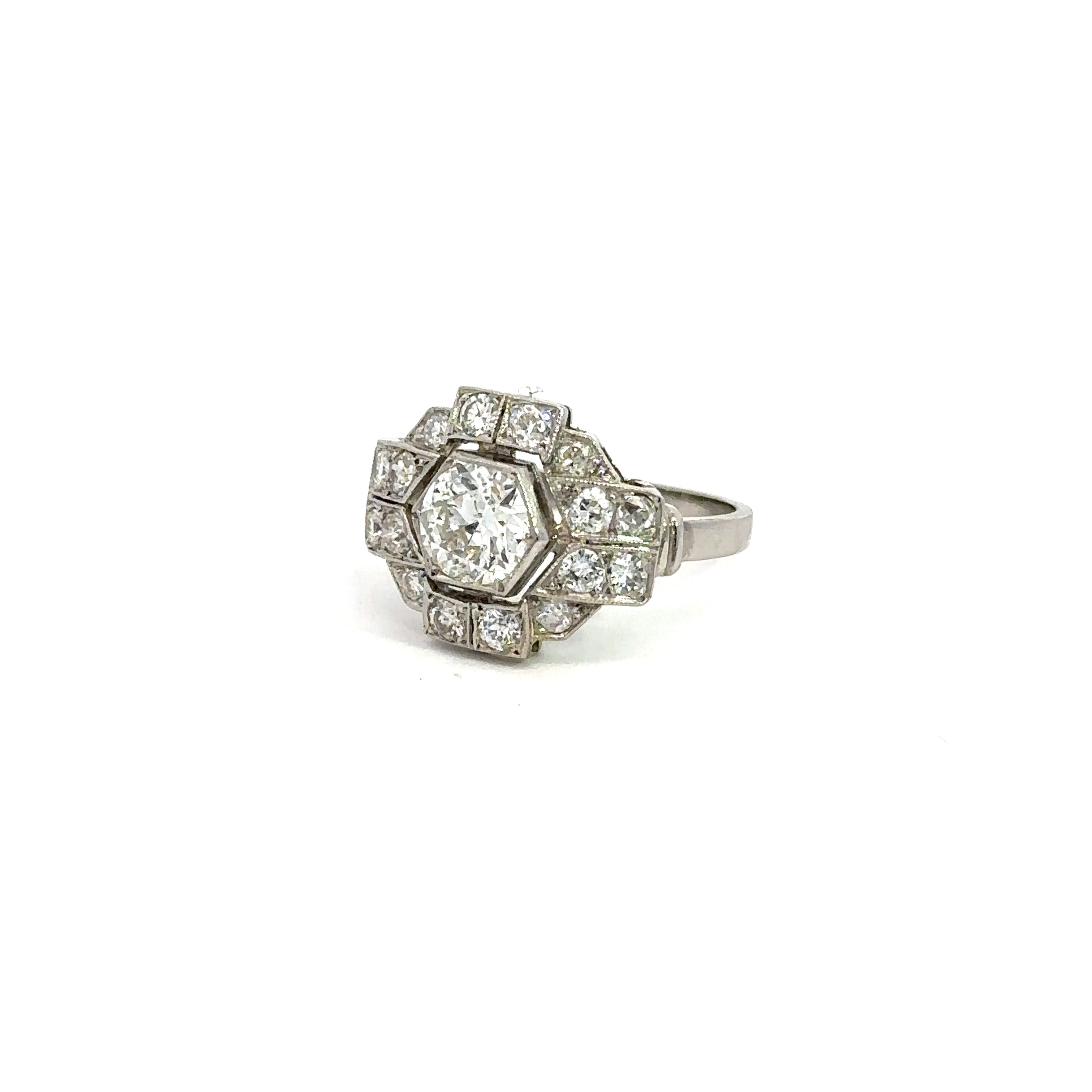 The Art Deco Platinum .95ct Old European Cut + 1.28cttw Diamond Ring exudes vintage sophistication, showcasing a meticulously crafted round Old European cut diamond encircled by smaller diamonds in a geometric hexagonal arrangement, with additional diamonds elegantly set into the band. The ring is flawlessly presented against a white background.
