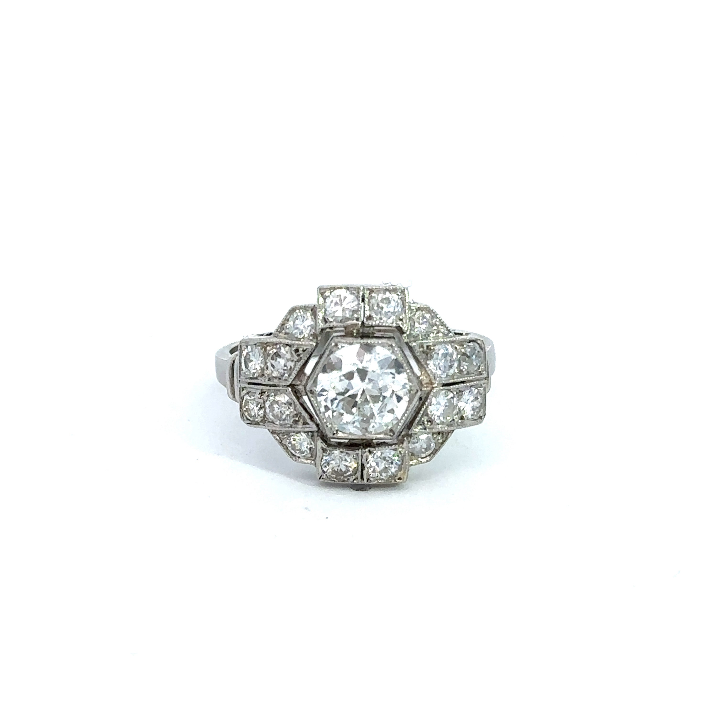 The Art Deco Platinum .95ct Old European Cut + 1.28cttw Diamond Ring exudes vintage sophistication, showcasing a meticulously crafted round Old European cut diamond encircled by smaller diamonds in a geometric hexagonal arrangement, with additional diamonds elegantly set into the band. The ring is flawlessly presented against a white background.