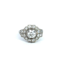 Load image into Gallery viewer, The Art Deco Platinum .95ct Old European Cut + 1.28cttw Diamond Ring exudes vintage sophistication, showcasing a meticulously crafted round Old European cut diamond encircled by smaller diamonds in a geometric hexagonal arrangement, with additional diamonds elegantly set into the band. The ring is flawlessly presented against a white background.