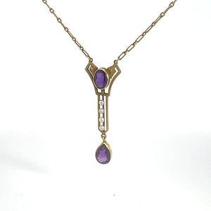 The Victorian 14kt Yellow Gold 3.50cttw Amethyst Pearl Lavalier Necklace showcases a central vertical pendant inspired by Victorian jewelry, featuring an oval amethyst gemstone at the top, three small white pearls in a row in the middle, and culminating with a larger teardrop-shaped amethyst gemstone at the bottom. The chain is composed of rectangular links.