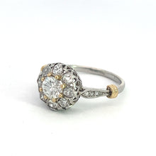 Load image into Gallery viewer, An exquisite Edwardian Platinum &amp; 18kt Yellow Gold 1.30cttw Old Mine Cut Diamond Ring showcasing a central round diamond encircled by a halo of smaller diamonds, set in an intricately designed vintage-inspired platinum and yellow gold band. The ring is displayed on a plain white background.