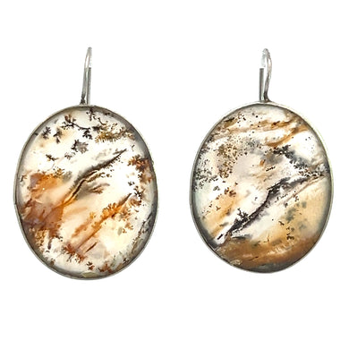 The Late Century Silver Moss Agate Earrings are oval-shaped with a silver hook, showcasing a natural stone design. Each stone displays an abstract pattern of brown, beige, and grey hues that evoke scenic landscapes or nature-inspired artwork, exuding natural elegance in every detail.