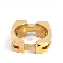 Load image into Gallery viewer, The Late Century 14ktyg Gauthier .35cttw Heavy Gold Ring is a chunky, square-shaped ring crafted from 14kt yellow gold and features a geometric design. A small black gemstone is embedded in one of its facets, and it has two vertical slots on opposite sides. The interior and edges are smooth and polished, highlighting the exceptional craftsmanship of this late century piece.