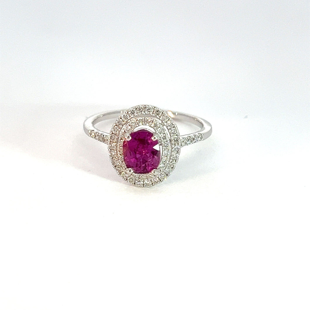 A Modern 18kt white gold ring featuring a 1.07-carat No Heat Purple Pink Sapphire at its center, surrounded by a double halo of .50cttw small, sparkling diamonds. The design is elegant and the gemstone is prominent against the white background.