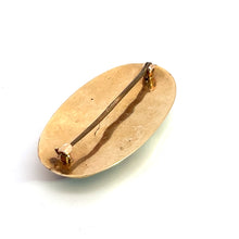 Load image into Gallery viewer, The Victorian 10ktyg Banded Agate Pin is a vintage oval-shaped brooch with a simple and minimalist design. It features a plain gold-tone surface and a horizontal pin fastening on the back. This piece of antique jewelry has a slightly worn, aged appearance, reminiscent of timeless Victorian jewelry treasures.