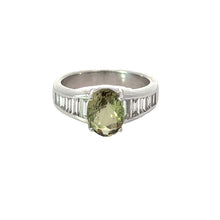 Load image into Gallery viewer, The Late Century Platinum 3.03ct Alexandrite + 1.28ctte Baguette Cut Diamonds ring showcases an oval-shaped, color-changing green alexandrite gemstone at its center, enhanced by rows of small, rectangular white diamond baguettes on each side and boasting a sleek and shiny finish.