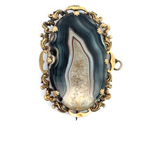 Load image into Gallery viewer, An ornate jewelry piece, this Victorian 10ktyg banded agate and quartz crystal pendant/pin features an oval banded agate centerpiece with multicolored layers in green, blue, and white. Set in an intricate gold-toned frame with decorative floral and scroll motifs, the pin and clasp are visible on the back.