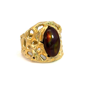 The Late Century 14ktyg Freeform 5ct Fire Agate Ring features an intricate, lace-like design crafted in 14kt yellow gold and boasts a large, oval-shaped fire agate gemstone at its center, which showcases iridescent hues of green and orange against a white background, exuding vintage charm.