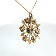 Load image into Gallery viewer, The Victorian 14ktyg .80cttw old mine cut diamond pendant showcases a circular design with intricate floral details and a central black gemstone. This striking pendant, inspired by the Victorian era, dangles elegantly from a delicate 14kt yellow gold chain against a plain white background.