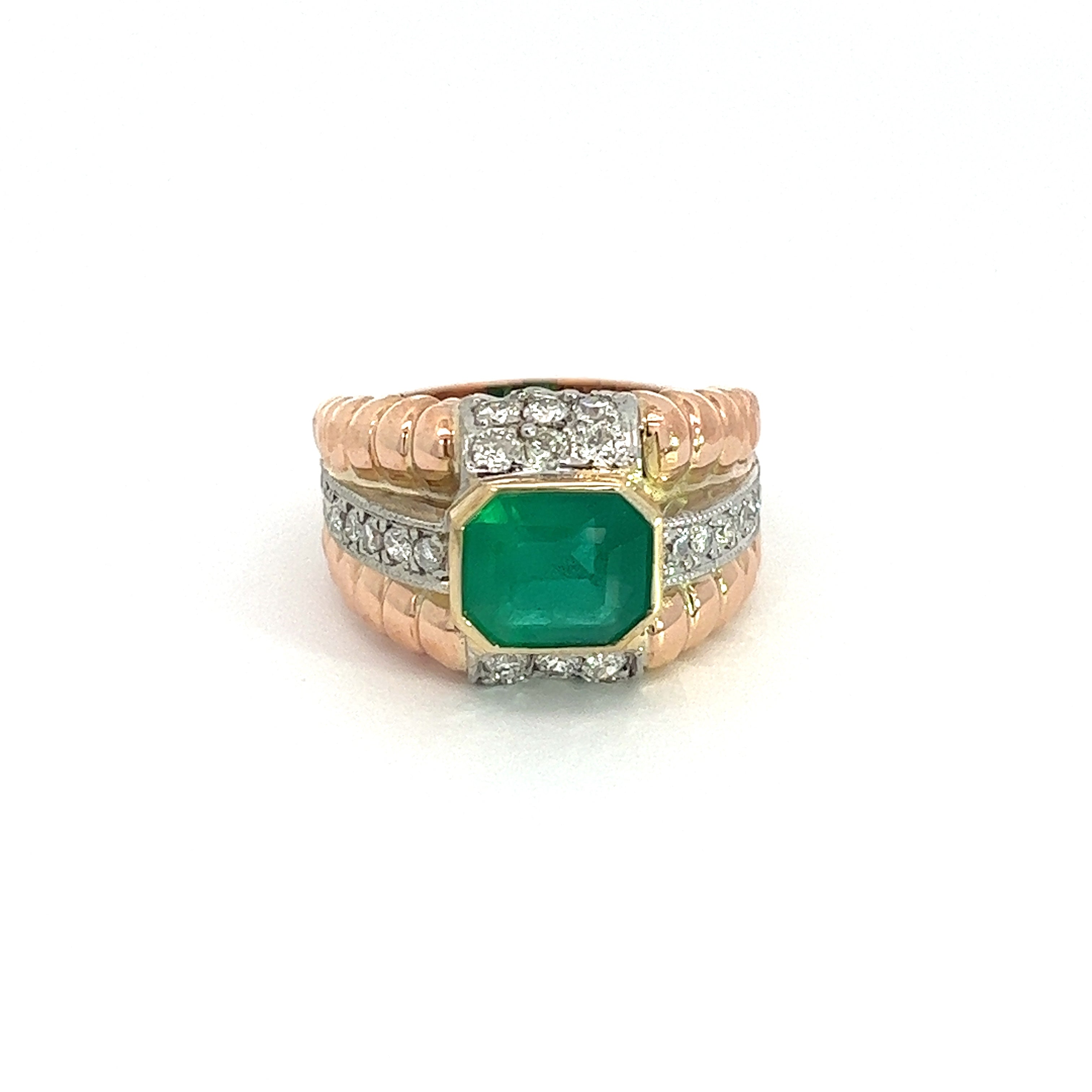 Introducing the "Late Century 18kt Rose & White Gold 2.50ct Emerald + 3cttw Diamonds Ring," a stunning piece featuring a large, square-cut emerald at its center, flanked by rows of small diamonds. The band showcases a ribbed texture and combines polished 18kt rose and white gold, with silver accents that beautifully surround the central gemstone.