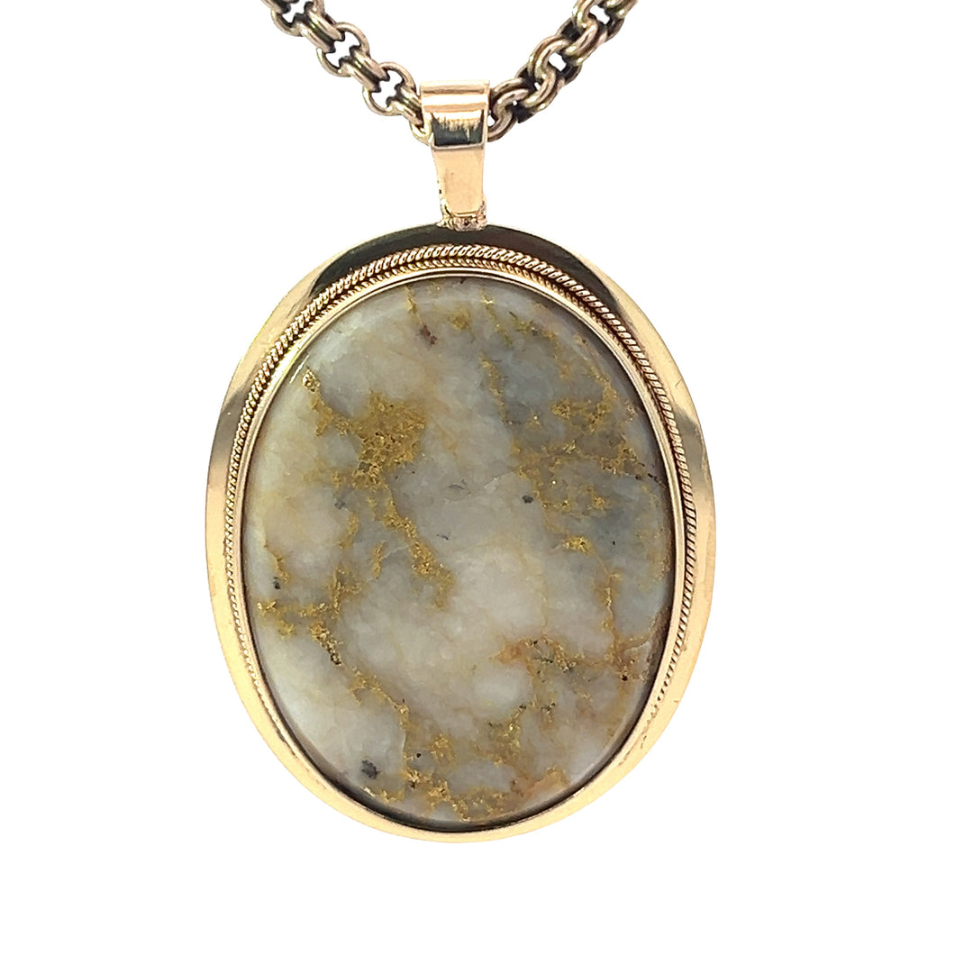 The Victorian 14ktyg Gold Quartz On 15ktyg 20 Inch Chain pendant, embodying Victorian luxury, features a polished quartz stone with a marbled pattern in shades of gray, white, and subtle gold veins. The oval-shaped pendant with a 14k yellow gold setting elegantly hangs from a textured 15k yellow gold chain.