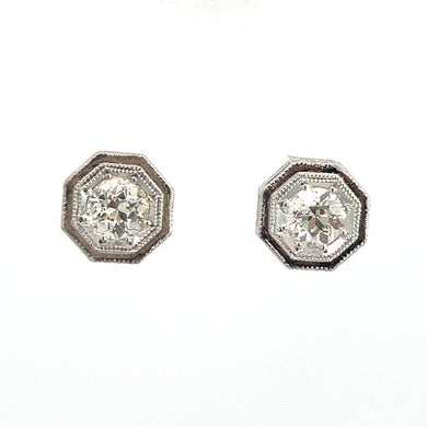 A pair of Art Deco Platinum Topped & 14kt White Gold 1.09ct Old European Cut Diamond Hexagon Frame Studs. Each earring features an old European cut diamond at the center, surrounded by intricate detailing on a plain white background.