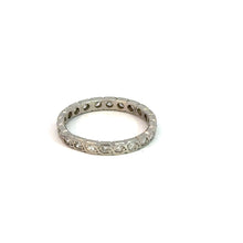 Load image into Gallery viewer, An Art Deco Platinum .50cttw Antique Cut Diamond Eternity Band, adorned with small, clear gemstones intricately embedded around the entire band, evokes a vintage-inspired classic charm. Photographed against a plain white background, this exquisite piece shines with the elegance of timeless design.